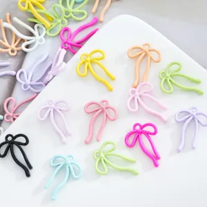 Détail en gros plan de charms nœud en alliage coloré, parfaits pour les bijoux DIY et loisirs.