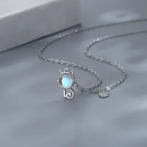Close-up of cute silver cat necklace with glowing moonstone pendant and paw heart charm