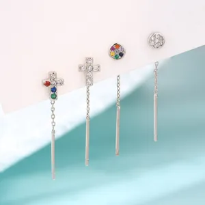 Détail de boucles d'oreilles traversantes en argent avec croix et zircons colorés