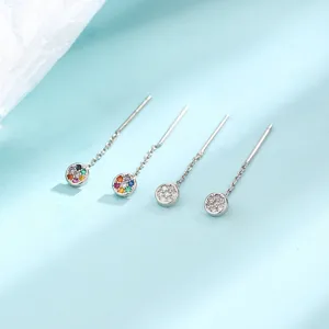 Gros plan de boucles d'oreilles pendantes en zircon arc-en-ciel et argent brillant.