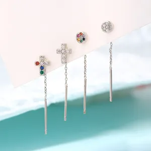Détail de boucles d'oreilles traversantes argentées avec oxydes de zirconium colorés.