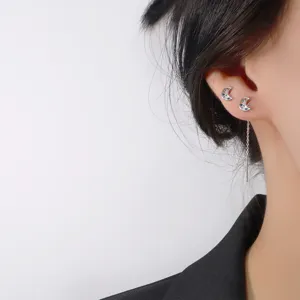 Close-up of elegant crescent moon ear threader earrings with rainbow cubic zirconia