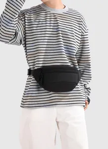 Close-up detail of a minimalist black fanny pack worn by a model for outdoor sports