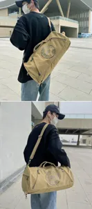 Detailed view of khaki canvas duffel bag being carried by an active model outdoors