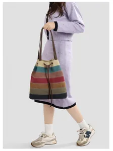 Vue détaillée du grand sac cabas en toile à rayures colorées porté par un mannequin