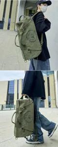 Lifestyle detail of an army green canvas travel duffle bag carried by a male model