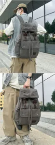 Close-up detail of a gray canvas drawstring backpack with classic leather buckle straps.
