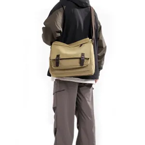 Back view detail of a men's khaki canvas messenger bag showing double buckles