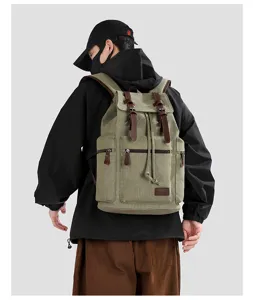 High-quality detailed shot of a green canvas travel backpack with leather straps on model