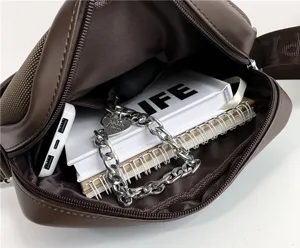 Close-up of interior compartment of brown men's crossbody bag showing storage capacity