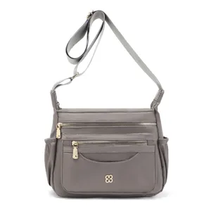 Detailed view of a grey multi-compartment nylon crossbody bag for women's daily travel.