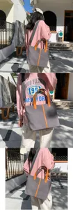 Gros plan d'un grand sac cabas en toile grise avec des accents orange porté par un mannequin.