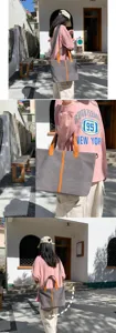 Grand sac cabas en toile grise avec garniture en cuir orange présenté en extérieur