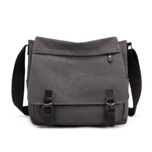 Detailed front view of a grey canvas messenger bag with leather buckle straps.
