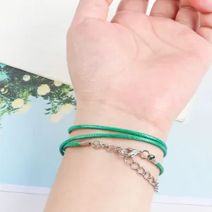 Macro view of green 1.5-2mm round wax cord bracelet with silver lobster clasp and chain