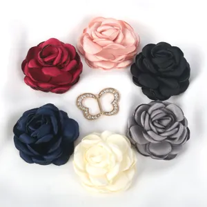 Détail en gros plan de fleurs en tissu multicolores et accessoires papillon en strass.