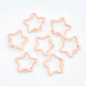 Close-up of peach painted star-shaped spring clasps for DIY jewelry making and keychains.