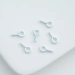 Closeup of white painted screw eyes, ideal for DIY phone case and keychain pendants