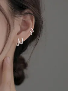 Κοντινό πλάνο με ασημένια σκουλαρίκια κρίκους με ζιργκόν φορεμένα μαζί