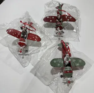 Detail view of three Christmas iron airplane ornaments featuring Santa, snowman and reindeer