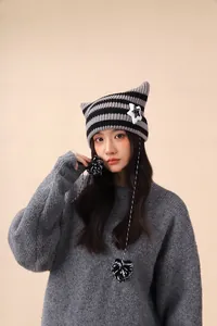 Detailed view of handmade striped beanie with cute cat ears and star patch accessory.