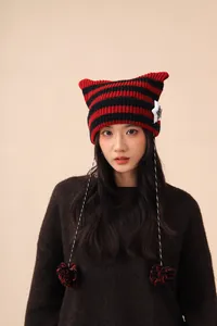 Macro detail view of a cute red and black striped cat ear beanie with star patches