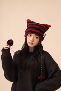 Red and black striped knitted beanie featuring cute cat ears and decorative pom-poms.