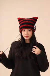 Close-up of cute striped cat ear beanie with star patch and pom-poms on model
