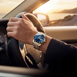 Luxury men's watch with blue dial and diamond markers worn by a driver at sunset