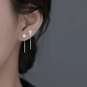 Élégantes boucles d'oreilles pendantes en argent avec croix et zircon rond sur modèle