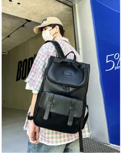 Grand sac à dos tendance en cuir PU noir pour hommes, porté par un jeune mannequin.
