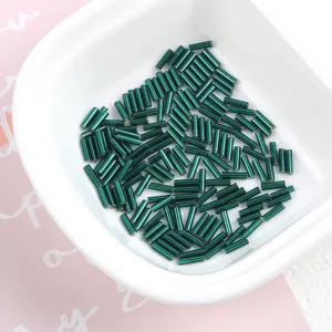 Detailed view of 2x7mm dark green silver-lined glass bugle beads for DIY jewelry