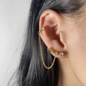 Vista dettagliata di un elegante earcuff a catena dorata con pietre di zircone.