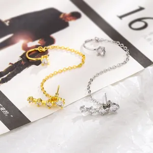 Vista dettagliata di ear cuff con catena in oro e argento e scintillanti zirconi.