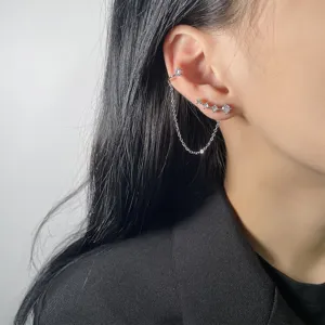 Dettaglio di orecchino a catena con zirconi lucenti con earcuff e perno integrato