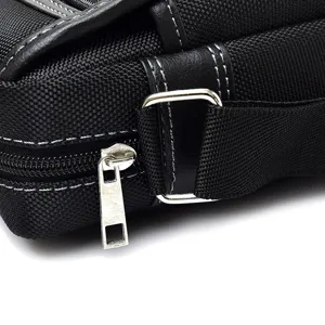 Close-up of black oxford cloth men's crossbody bag with a durable metal zipper detail