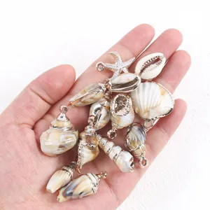 Primo piano di ciondoli con conchiglie e stelle marine dorate per accessori fai da te.