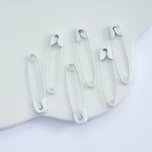 Detailed close-up view of white alloy safety pins, perfect for DIY jewelry and craft accessories.