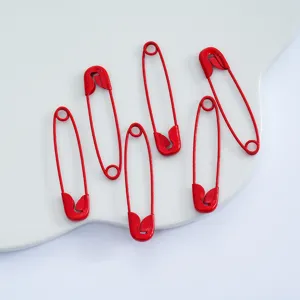 Close up of red baked paint safety pins, ideal for DIY jewelry making and craft accessories.
