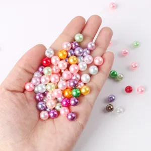 Close-up of colorful ABS imitation pearl beads held in hand for DIY jewelry and phone case making.