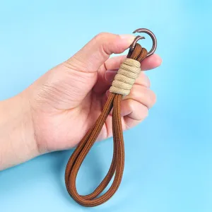 Detail of a handmade braided brown phone lanyard with a brown metal ring hook