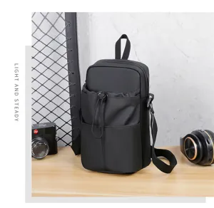 Detailed view of black multi-compartment crossbody water bottle bag for travel