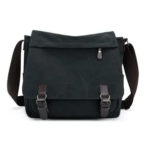 Full front view showing texture of black canvas messenger bag with brown straps and buckles.