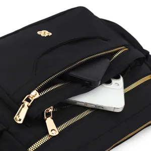 Close-up of black multi-compartment crossbody bag showing phone and power bank storage