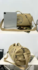 Detailed view of khaki canvas barrel bag featuring top handles and shoulder strap