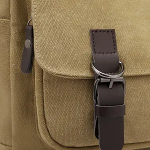Close-up of durable khaki canvas bag with brown leather strap and metal buckle detail