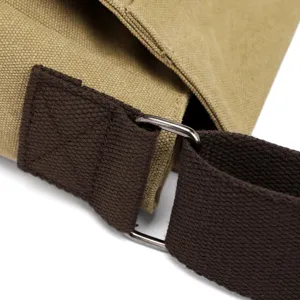 Close-up of durable canvas strap attachment on men's messenger bag with metal ring.