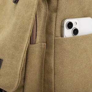 Close-up detail of a durable canvas messenger bag side pocket with a smartphone inside.