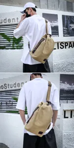Macro view of a durable khaki canvas sling bag worn by a model in an urban setting.