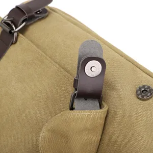 Detailed macro shot of a durable canvas bag with a magnetic snap button and leather strap.
